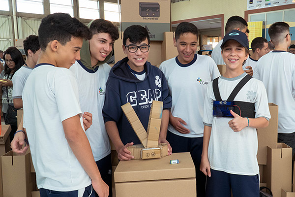 Cinco alunos mostram um protótipo de papelão